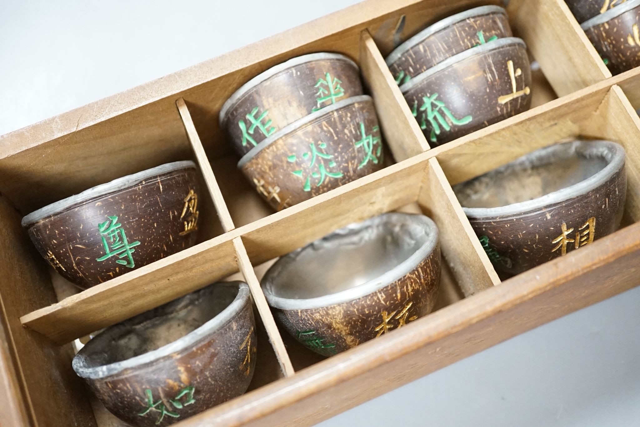 An early 20th century Chinese cased set of coconut cups with pewter liners